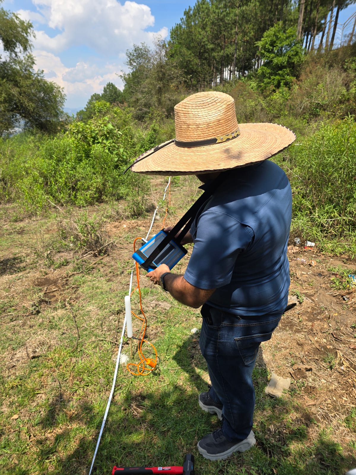 Trabajo de campo con equipo de medición y línea desplegada sobre el terreno